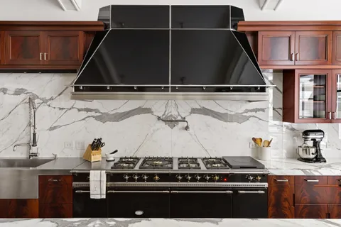 a stove top oven sitting inside of a kitchen