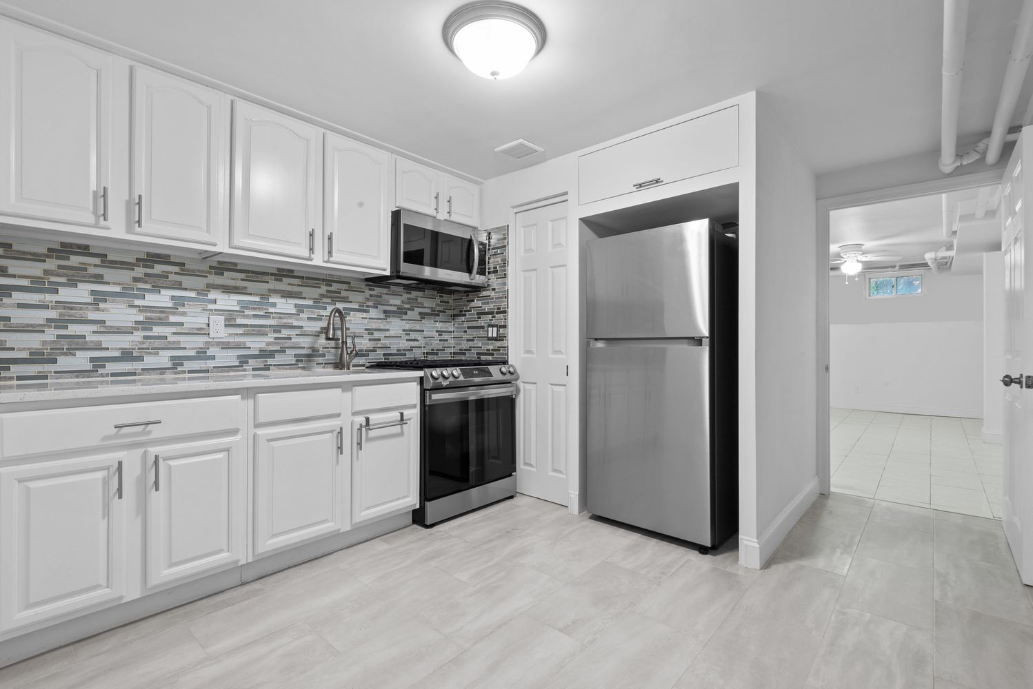 18-91 Stockholm Street, Unit 1 Queens, NY 11385 - Photo 2 of 5 a kitchen with stainless steel appliances granite countertop a refrigerator sink and cabinets
