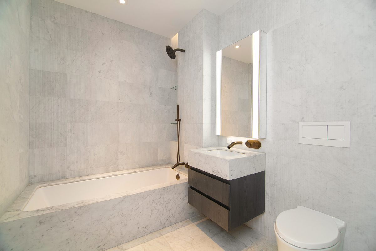 130 William Street, Unit 9E Manhattan, NY 10038 - Photo 5 of 16 a bathroom with a sink a toilet and bathtub