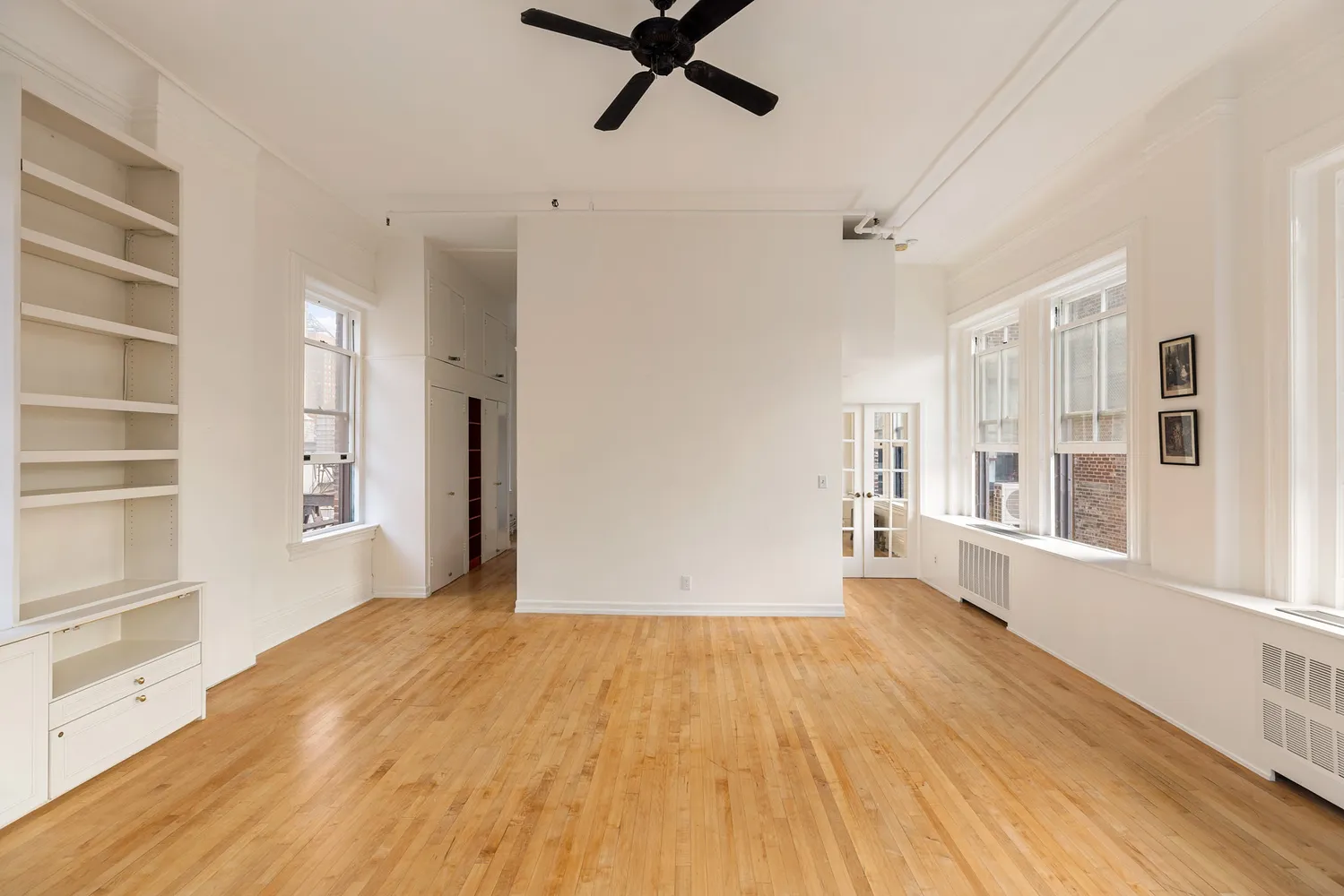 a view of a big room with wooden floor and windows