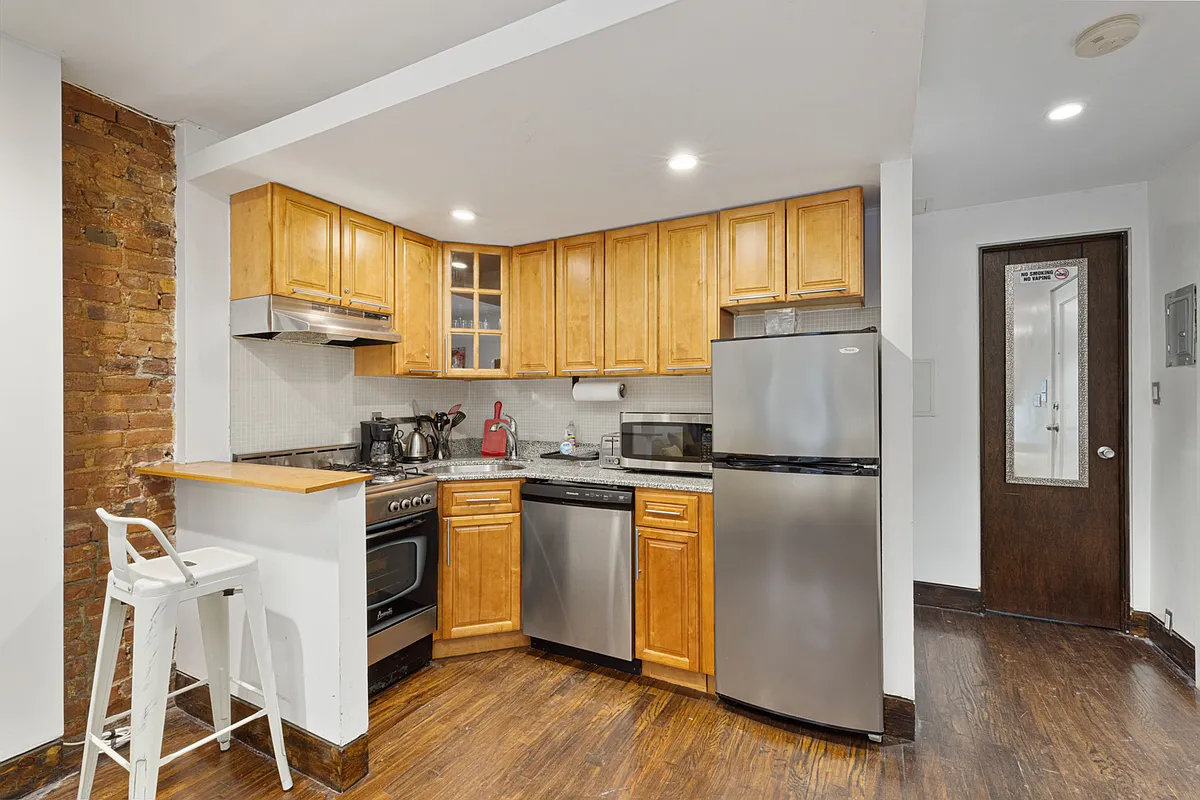 258 Clinton Avenue, Unit 1F Brooklyn, NY 11205 - Photo 3 of 6 a kitchen with stainless steel appliances granite countertop a refrigerator a stove top oven a sink and dishwasher with wooden floor