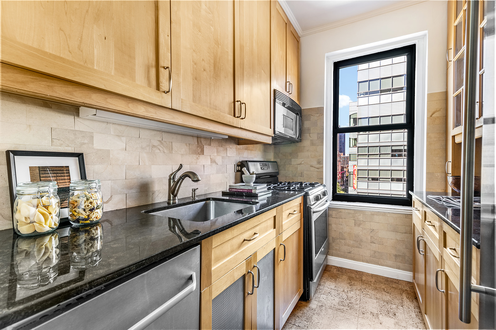 357 West 55th Street, Unit 4D Manhattan, NY 10019 - Photo 5 of 11 a kitchen with stainless steel appliances granite countertop a sink stove and cabinets