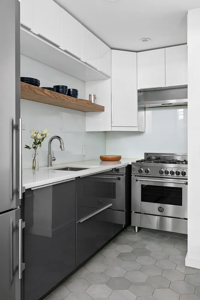 a kitchen with stainless steel appliances a refrigerator a sink a table and chairs