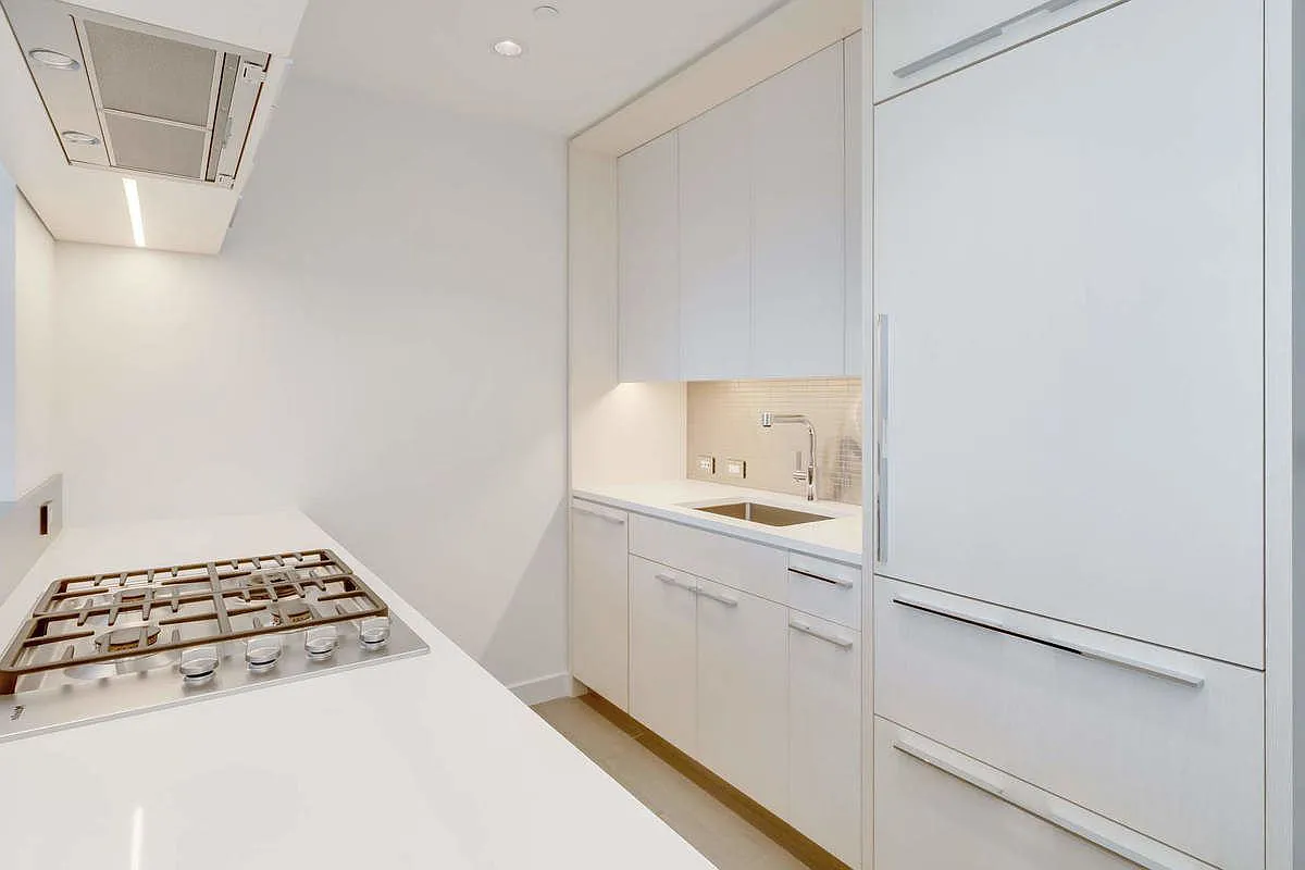 252 South Street, Unit 52J Manhattan, NY 10002 - Photo 5 of 17 a kitchen with a stove and a white cabinet