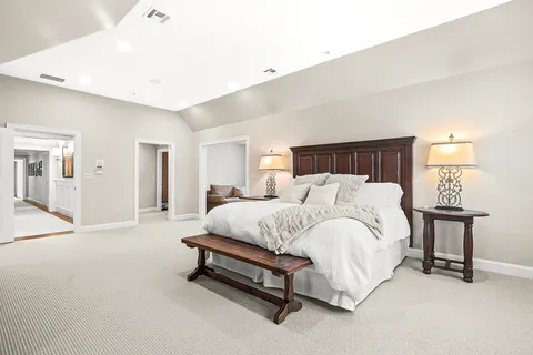 a spacious bedroom with a bed and a lamp