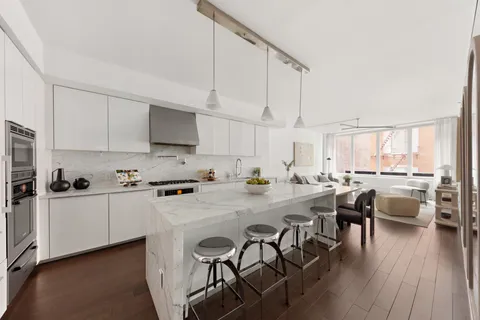 a kitchen with white cabinets and chairs