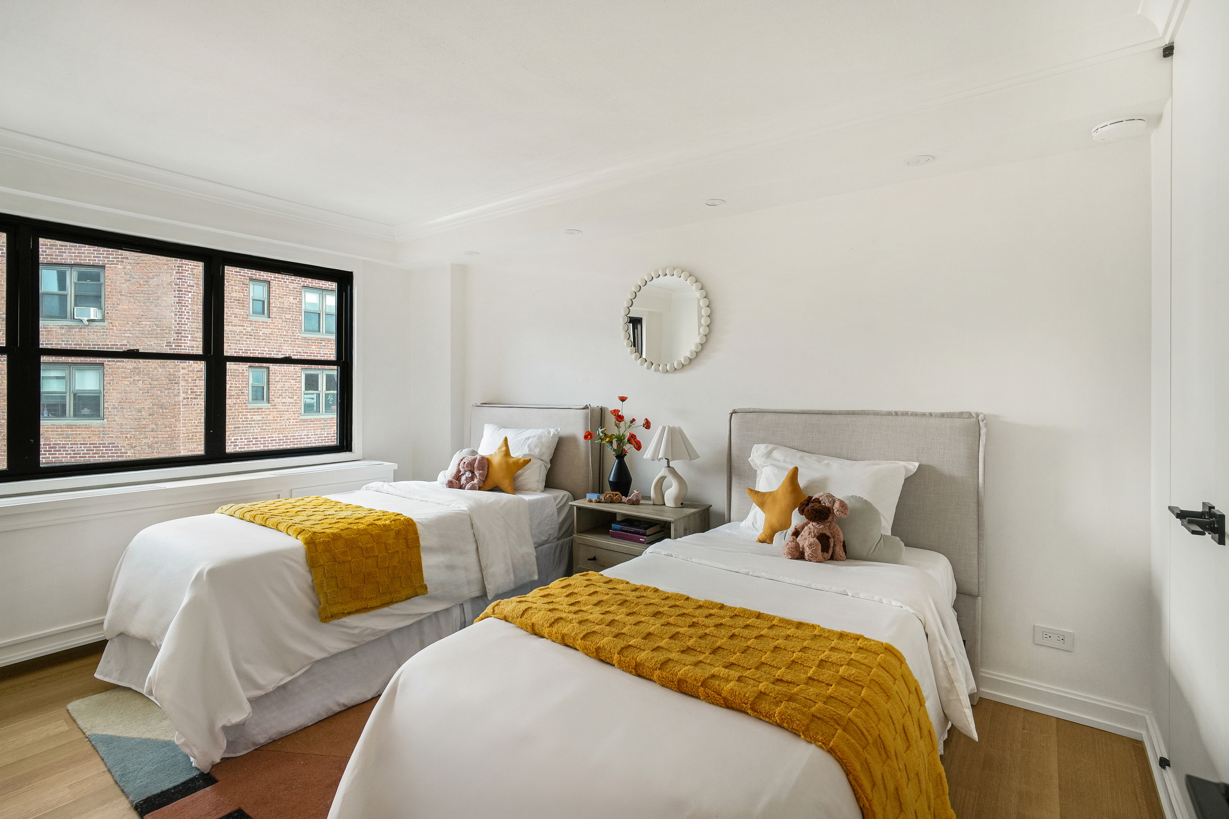 31 Jane Street, Unit 10FG Manhattan, NY 10014 - Photo 16 of 27 a bedroom with two beds and a large window