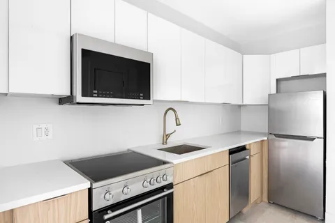 a kitchen with stainless steel appliances granite countertop a stove microwave and refrigerator