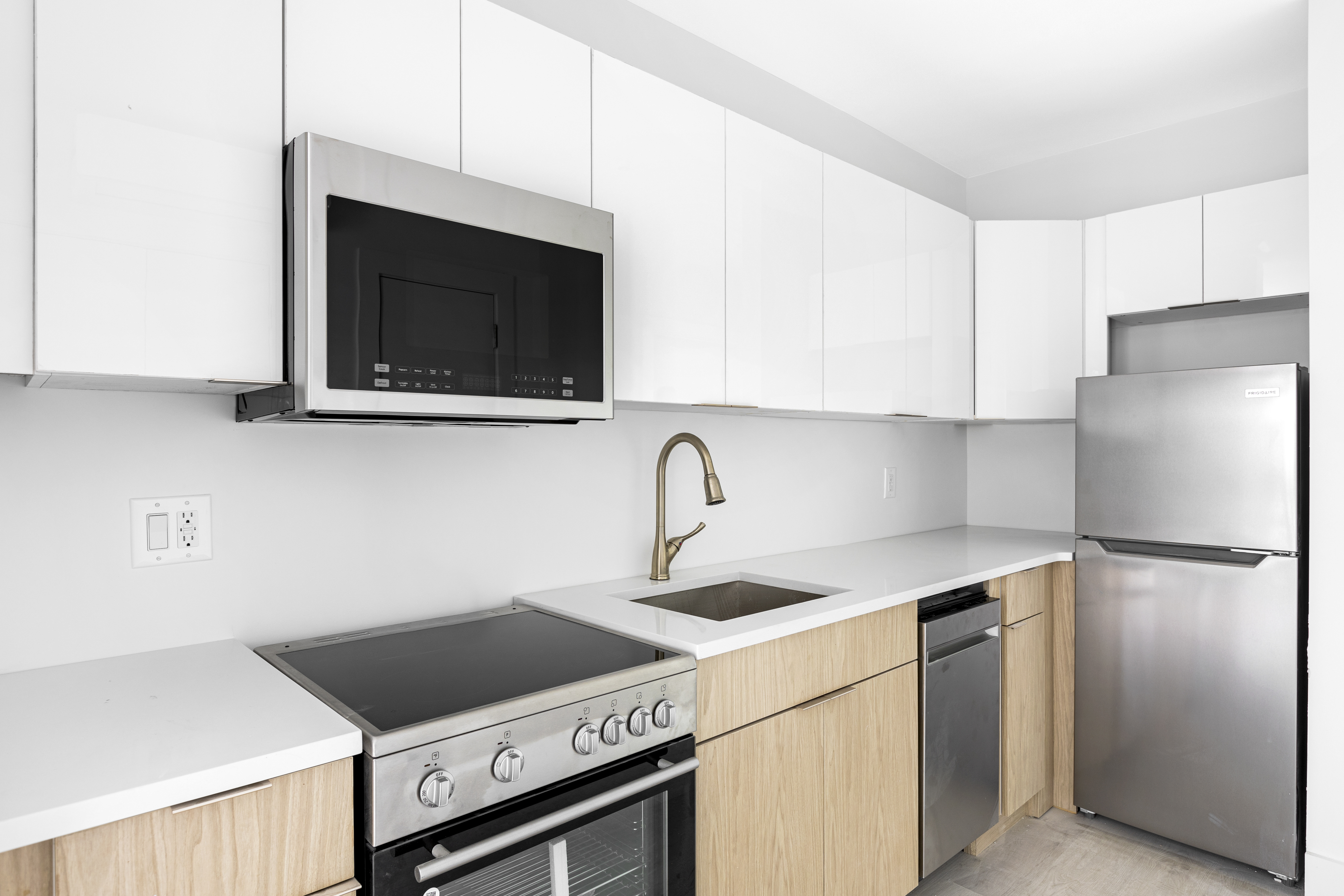 1463 New York Avenue, Unit 5B Brooklyn, NY 11210 - Photo 3 of 8 a kitchen with stainless steel appliances granite countertop a stove microwave and refrigerator