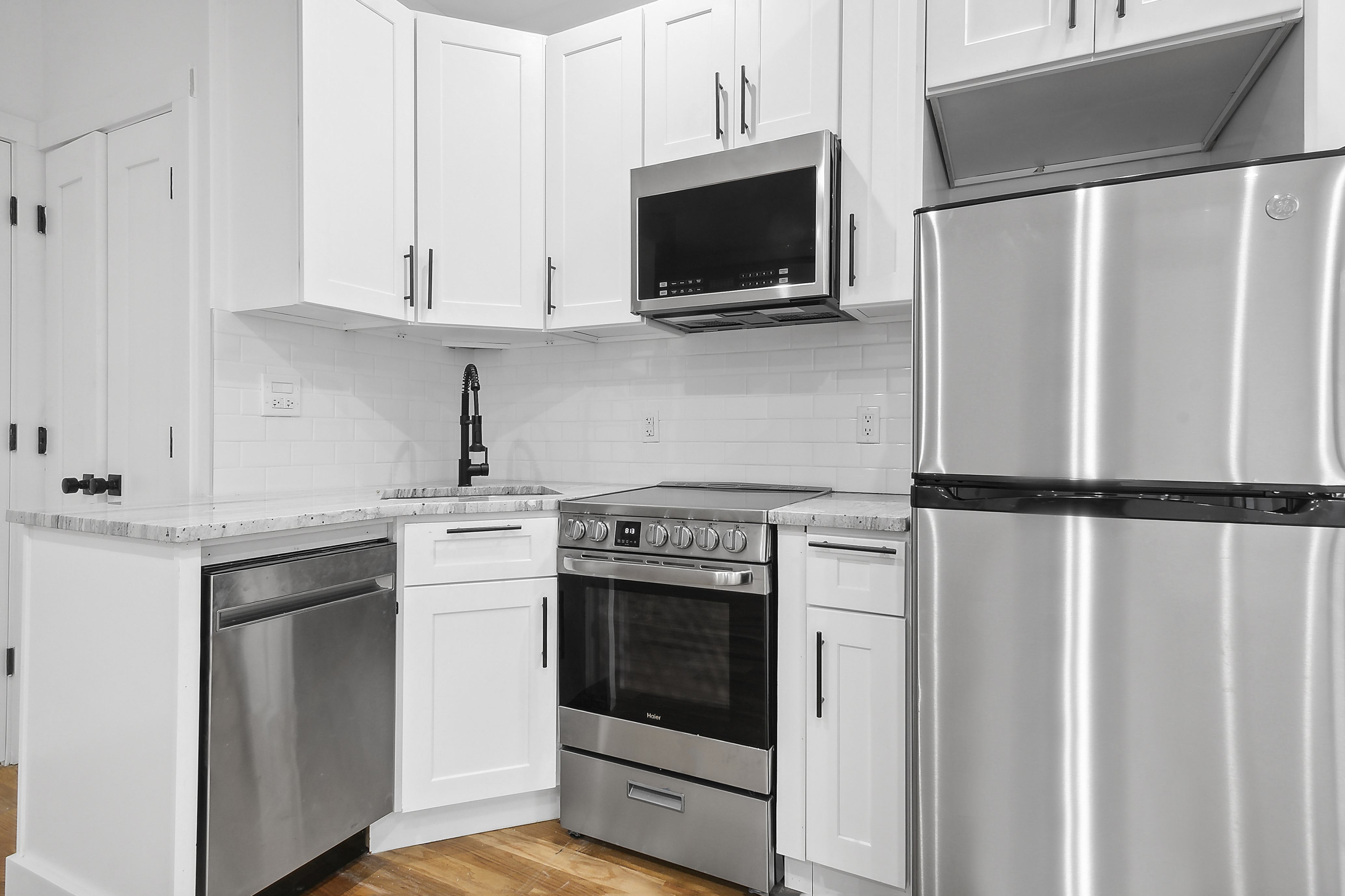 119 Woodbine Street, Unit 2 Brooklyn, NY 11221 - Photo 4 of 6 a kitchen with cabinets stainless steel appliances and wooden floor