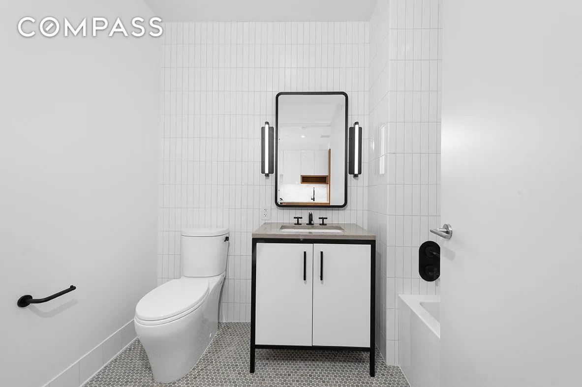 a bathroom with a toilet a sink a vanity and mirror