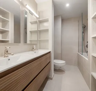 a bathroom with a double vanity sink toilet and a tub