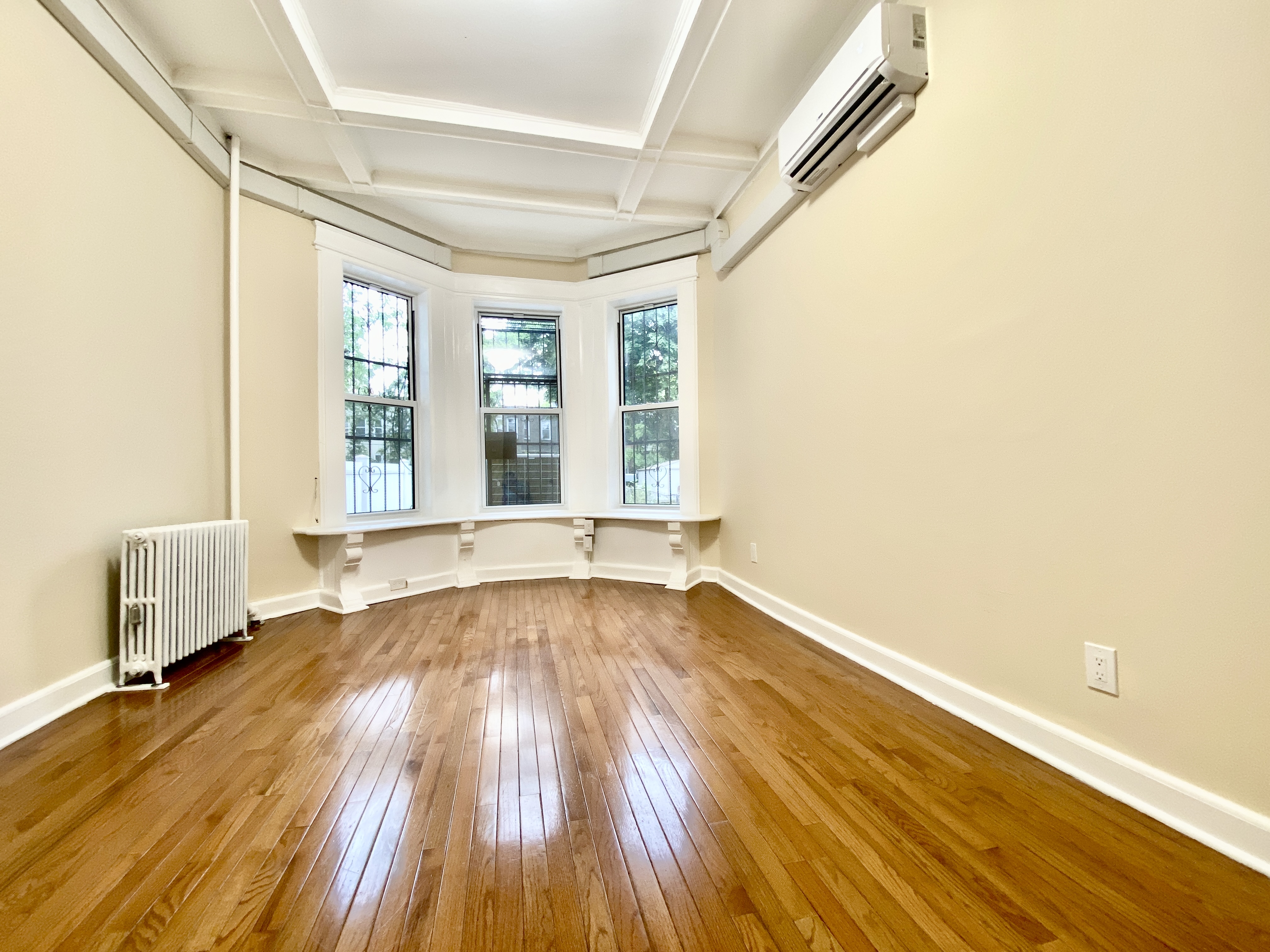 1308 Park Place, Unit 1 Brooklyn, NY 11213 - Photo 5 of 9 an empty room with wooden floor and windows