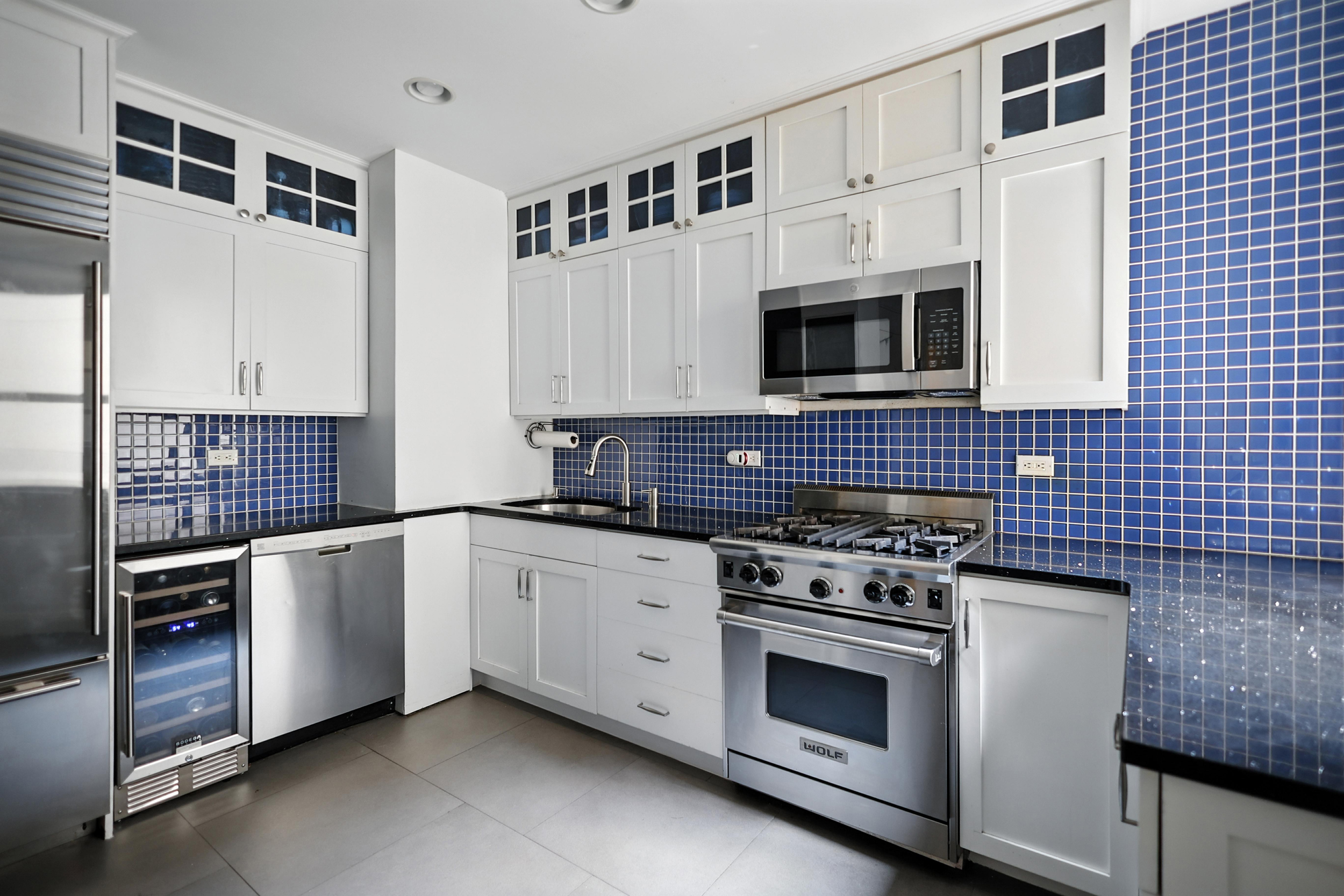 215 West 75th Street, Unit 6B Manhattan, NY 10023 - Photo 5 of 12 a kitchen with stainless steel appliances white cabinets and stove top oven