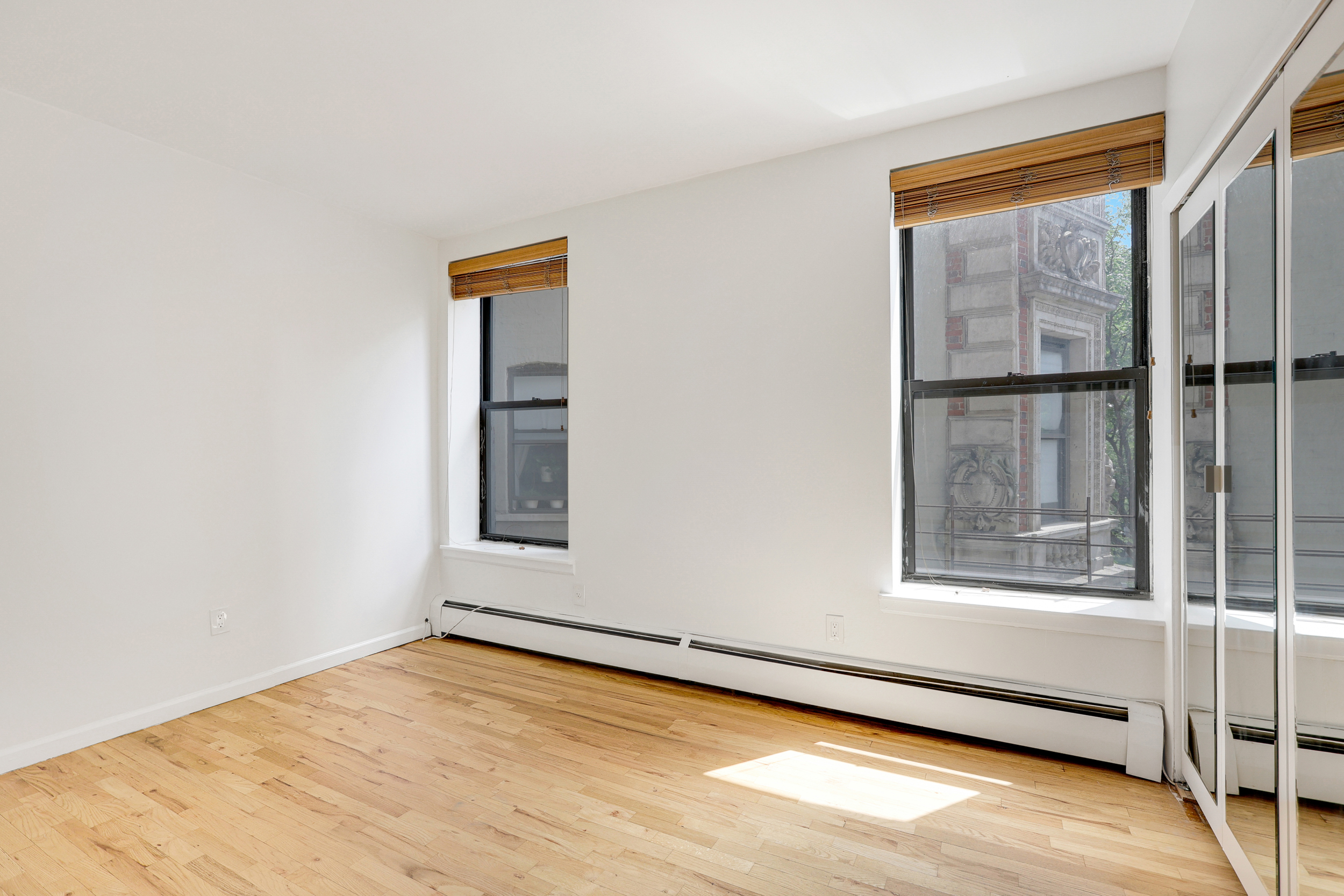 66-72 St Nicholas Avenue, Unit 3G Manhattan, NY 10026 - Photo 8 of 15 a view of an empty room with wooden floor and a window
