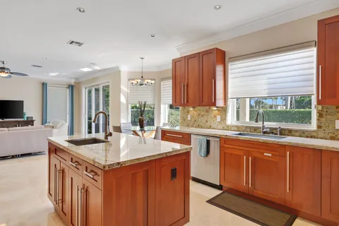 a kitchen with stainless steel appliances granite countertop a sink and a large window