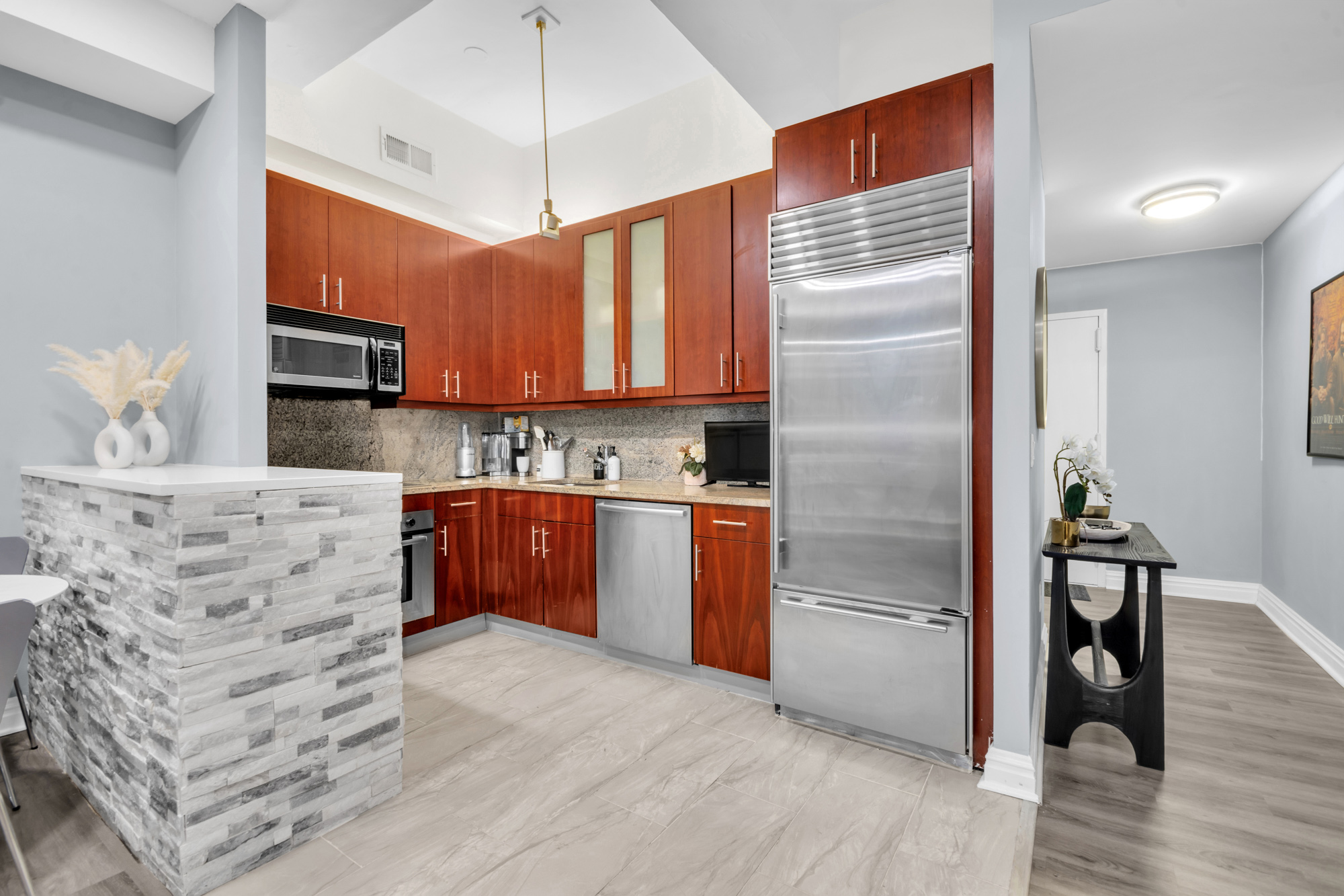 80 John Street, Unit 14D Manhattan, NY 10038 - Photo 4 of 8 a kitchen with stainless steel appliances kitchen island granite countertop a refrigerator a stove and a wooden floors