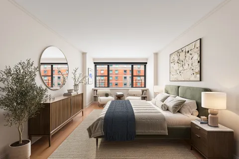 a large bedroom with a large bed a chandelier and windows