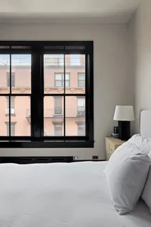 a bedroom with furniture and a large window