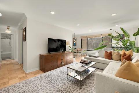a living room with furniture a flat screen tv and a rug