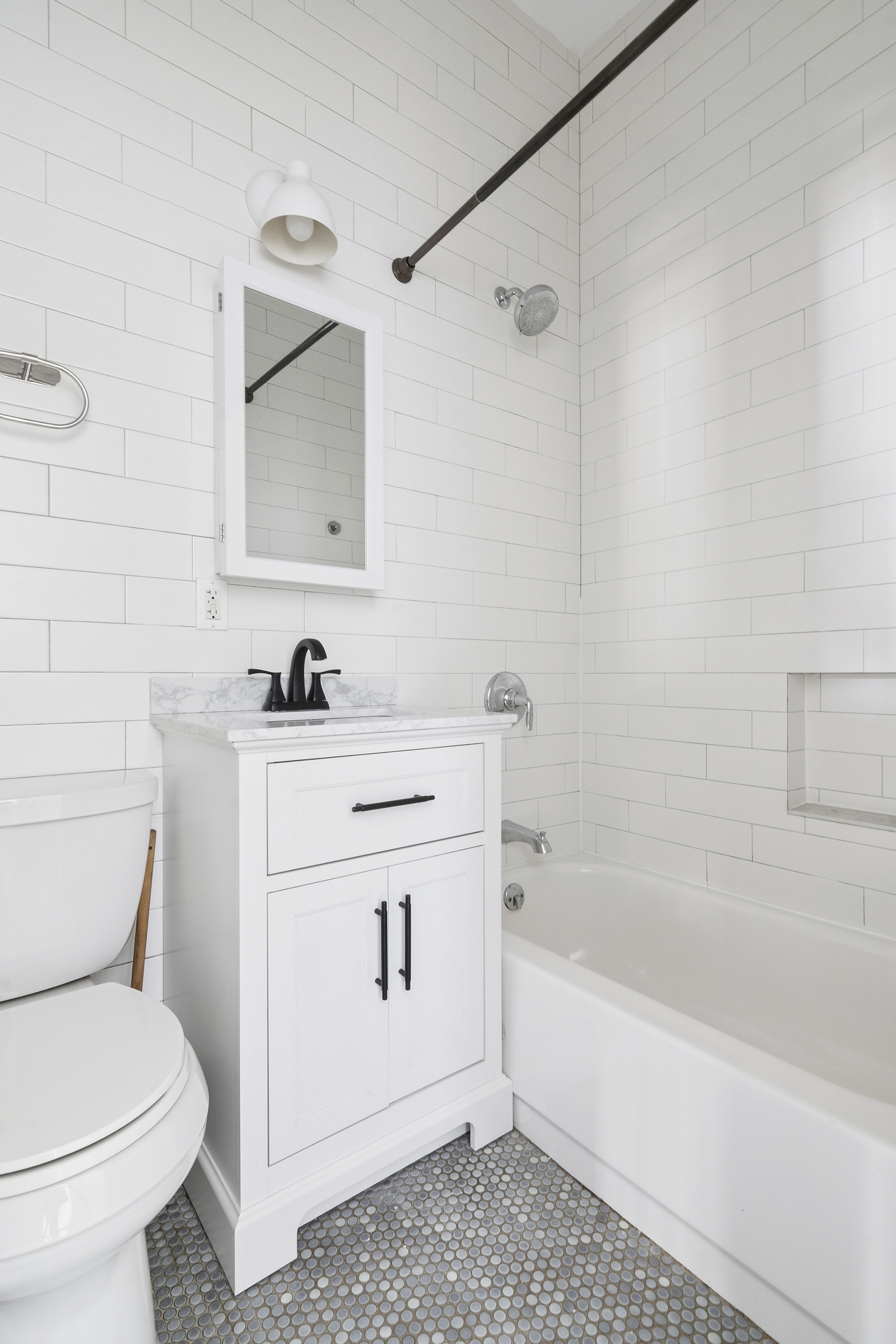 239 East 23rd Street, Unit 2 Brooklyn, NY 11226 - Photo 5 of 8 a bathroom with a sink toilet and vanity