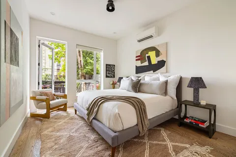 a bedroom with a bed a couch and a window