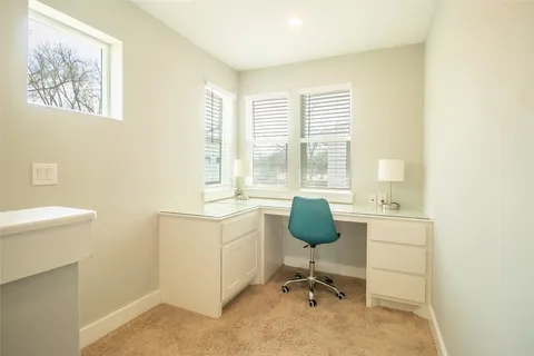 a view of a workspace with furniture and a window