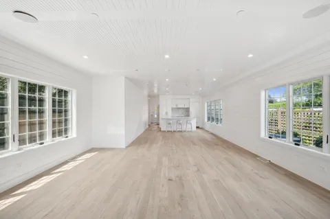 a kitchen with white cabinets and chairs