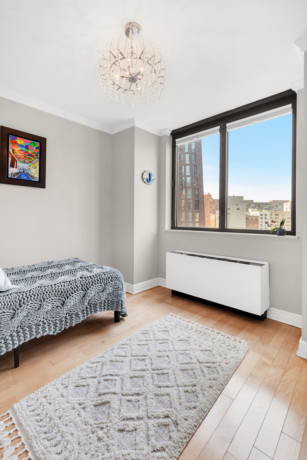 630 1st Avenue, Unit 16JK Manhattan, NY 10016 - Photo 8 of 13 a living room with a bed and a large window
