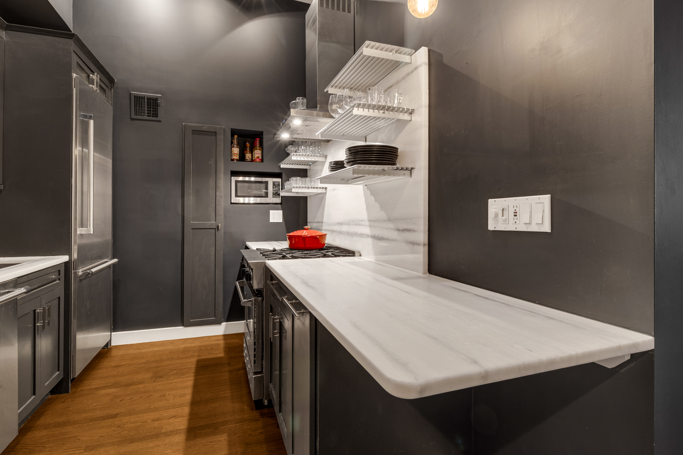 521 West 47th Street, Unit 3A Manhattan, NY 10036 - Photo 8 of 13 a kitchen with granite countertop a refrigerator a stove and a sink