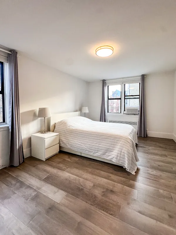 a spacious bedroom with a bed and a window