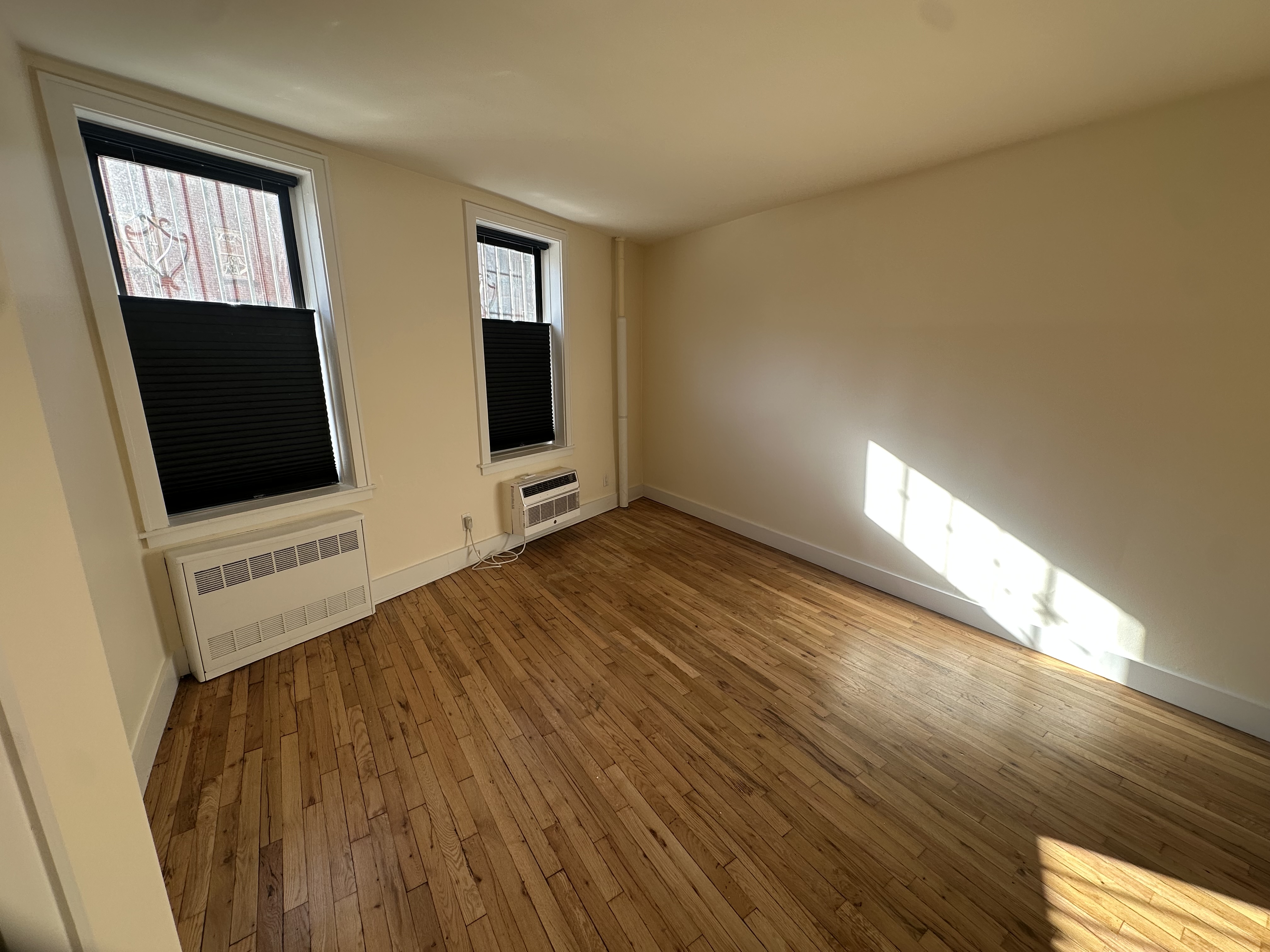 752 Greenwich Street, Unit 1A/B Manhattan, NY 10014 - Photo 7 of 12 a view of an empty room with wooden floor and a window