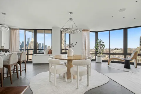 a dining room with furniture water view and large windows