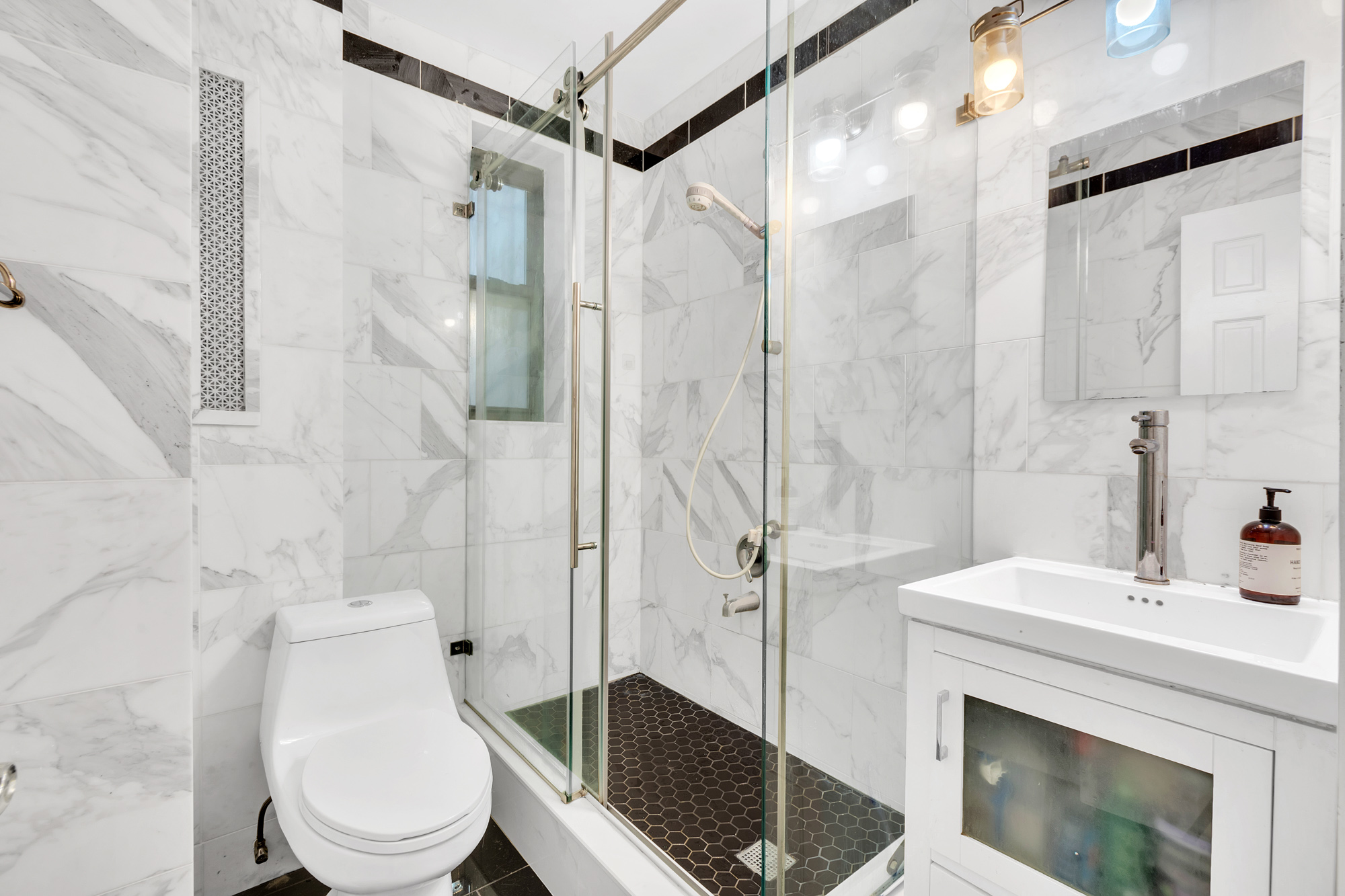 26 West 97th Street, Unit 2C Manhattan, NY 10025 - Photo 6 of 9 a bathroom with a sink toilet and shower