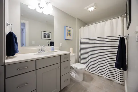 a bathroom with a toilet a sink and mirror