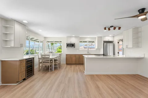 a kitchen with stainless steel appliances kitchen island hardwood floor sink stove dining table and chairs