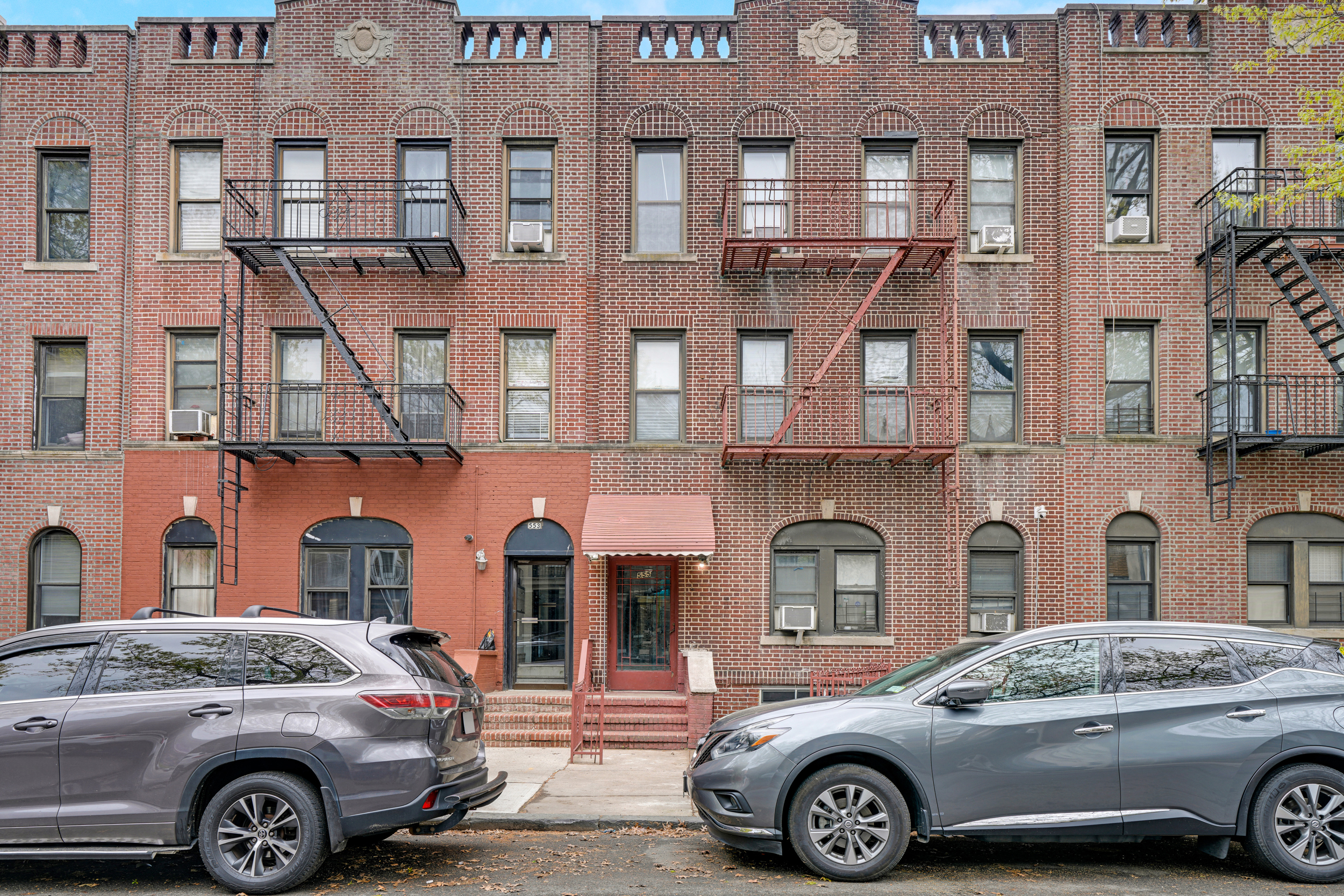 a front view of a residential apartment building with parking space