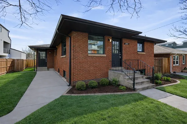 a front view of a house with a yard and outdoor seating