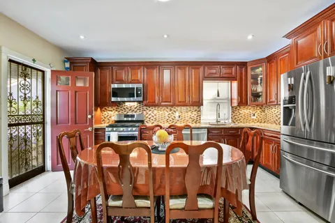 a kitchen with granite countertop a refrigerator stove microwave and cabinets