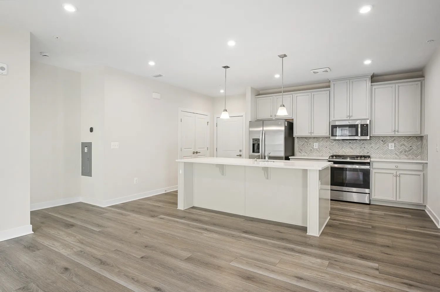 a kitchen with a refrigerator and white cabinets