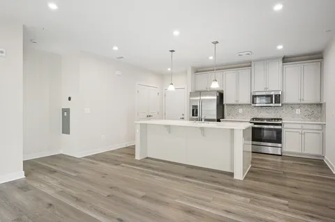 a kitchen with a refrigerator and white cabinets