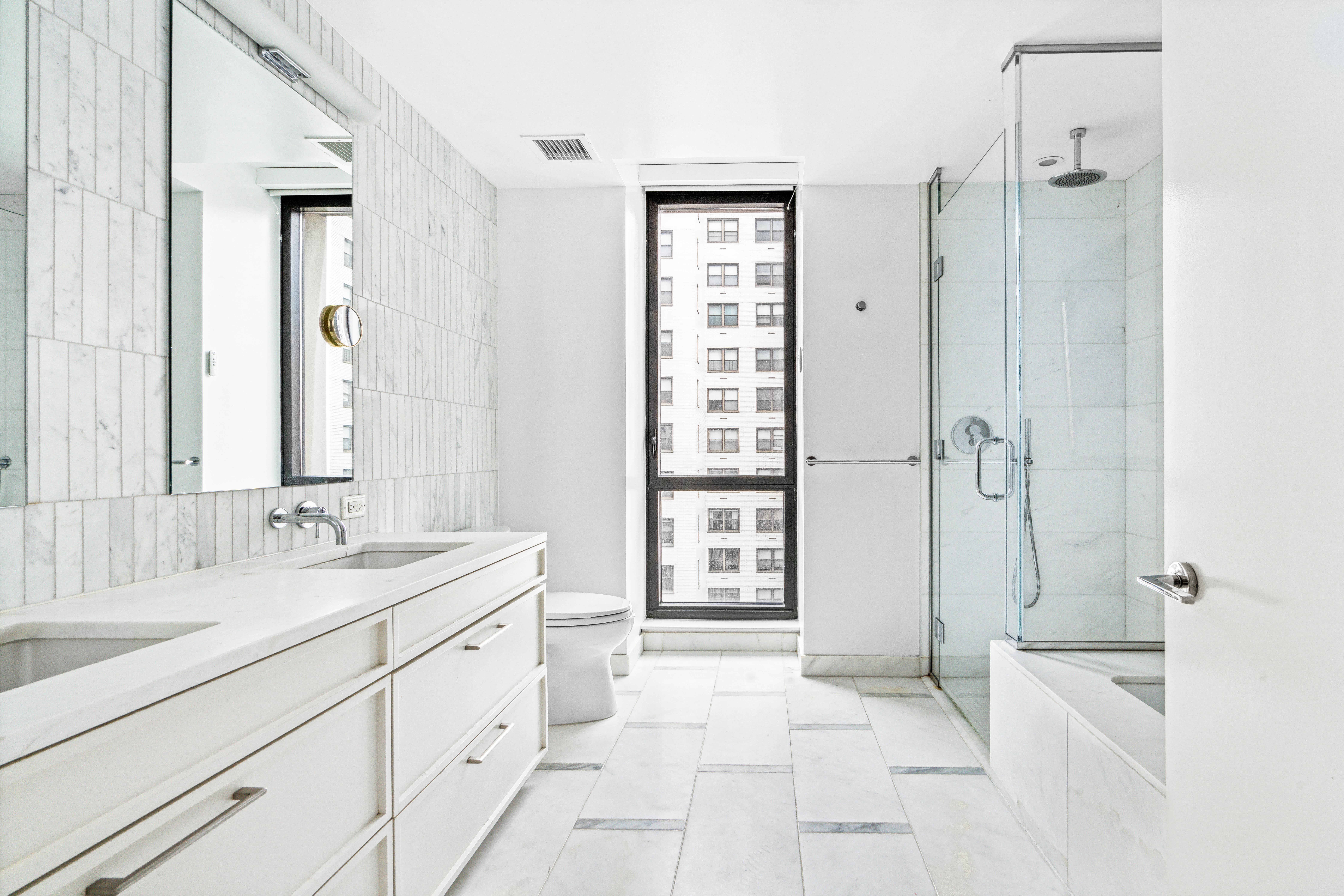 160 East 22nd Street, Unit 9E Manhattan, NY 10010 - Photo 7 of 17 a spacious bathroom with a shower sink and mirror