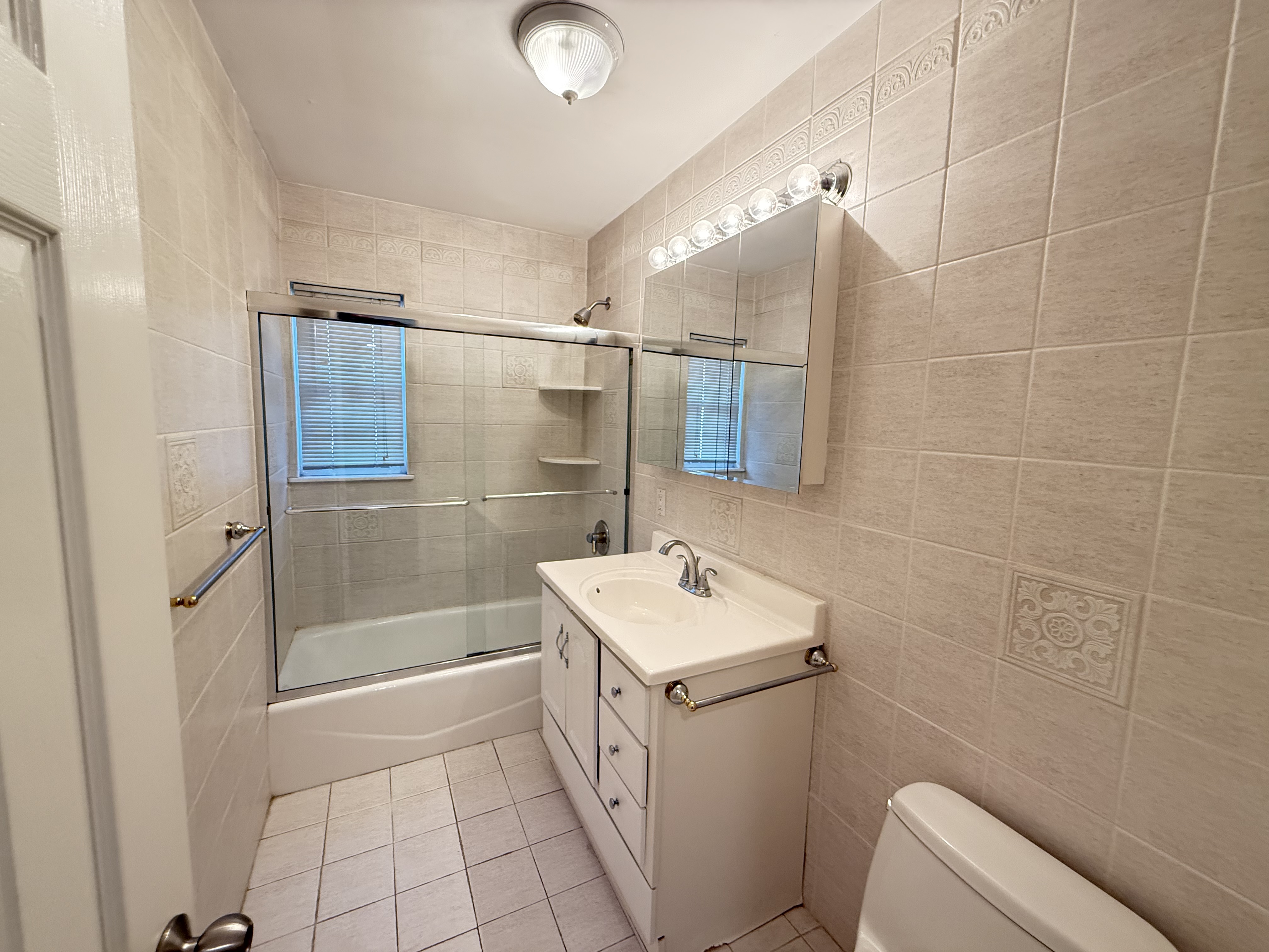 3236 Country Club Road Bronx, NY 10465 - Photo 14 of 22 a bathroom with a sink a toilet and shower
