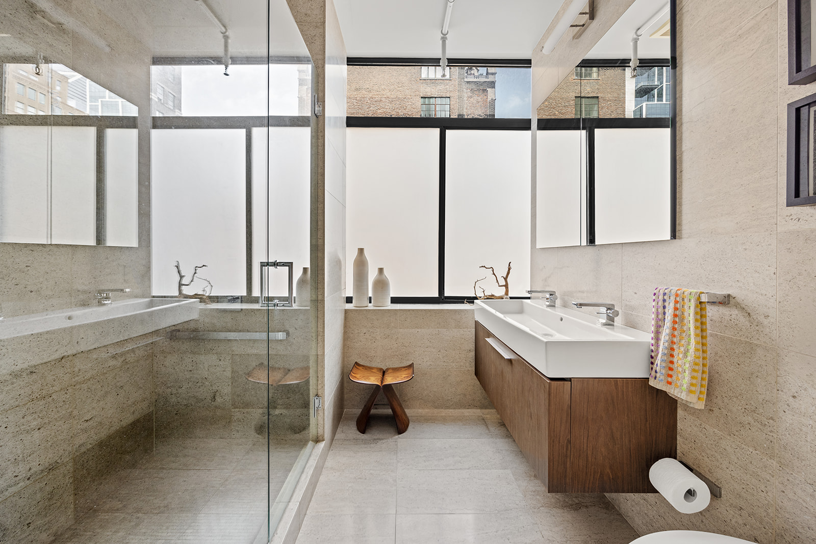 348 West 36th Street, Unit 6N Manhattan, NY 10018 - Photo 7 of 12 a bathroom with a double vanity sink a mirror and a bathtub