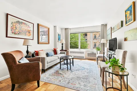 a living room with furniture a flat screen tv and a large window