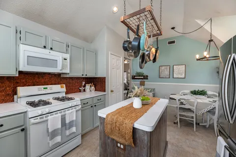 a kitchen with stainless steel appliances granite countertop a white cabinets and stove top oven