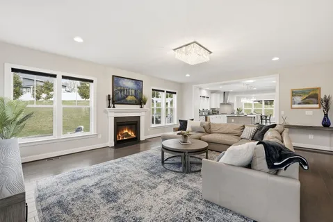 a living room with furniture a fireplace and a large window