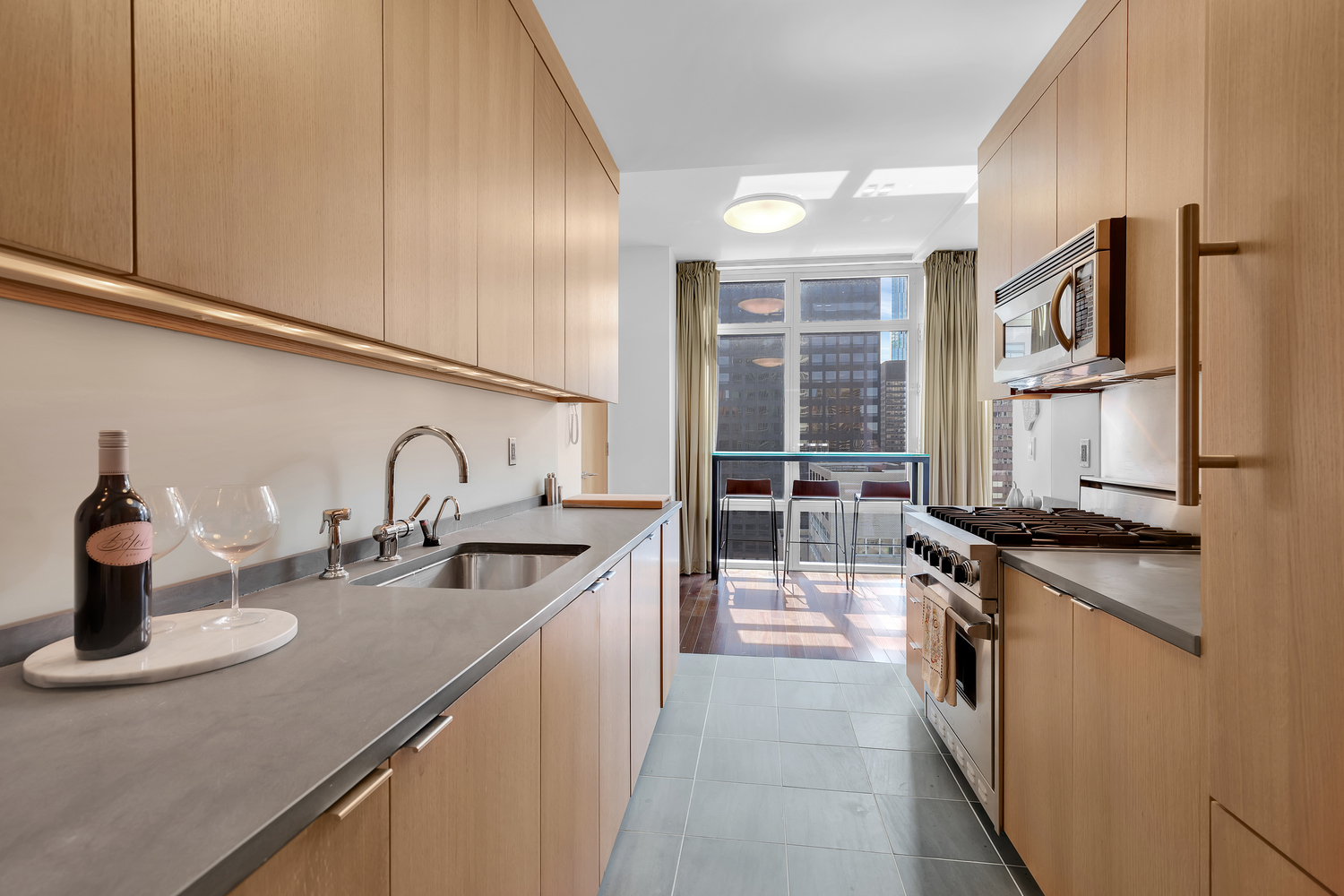 207 East 57th Street, Unit 25B Manhattan, NY 10022 - Photo 5 of 19 a kitchen with stainless steel appliances granite countertop a sink and a stove