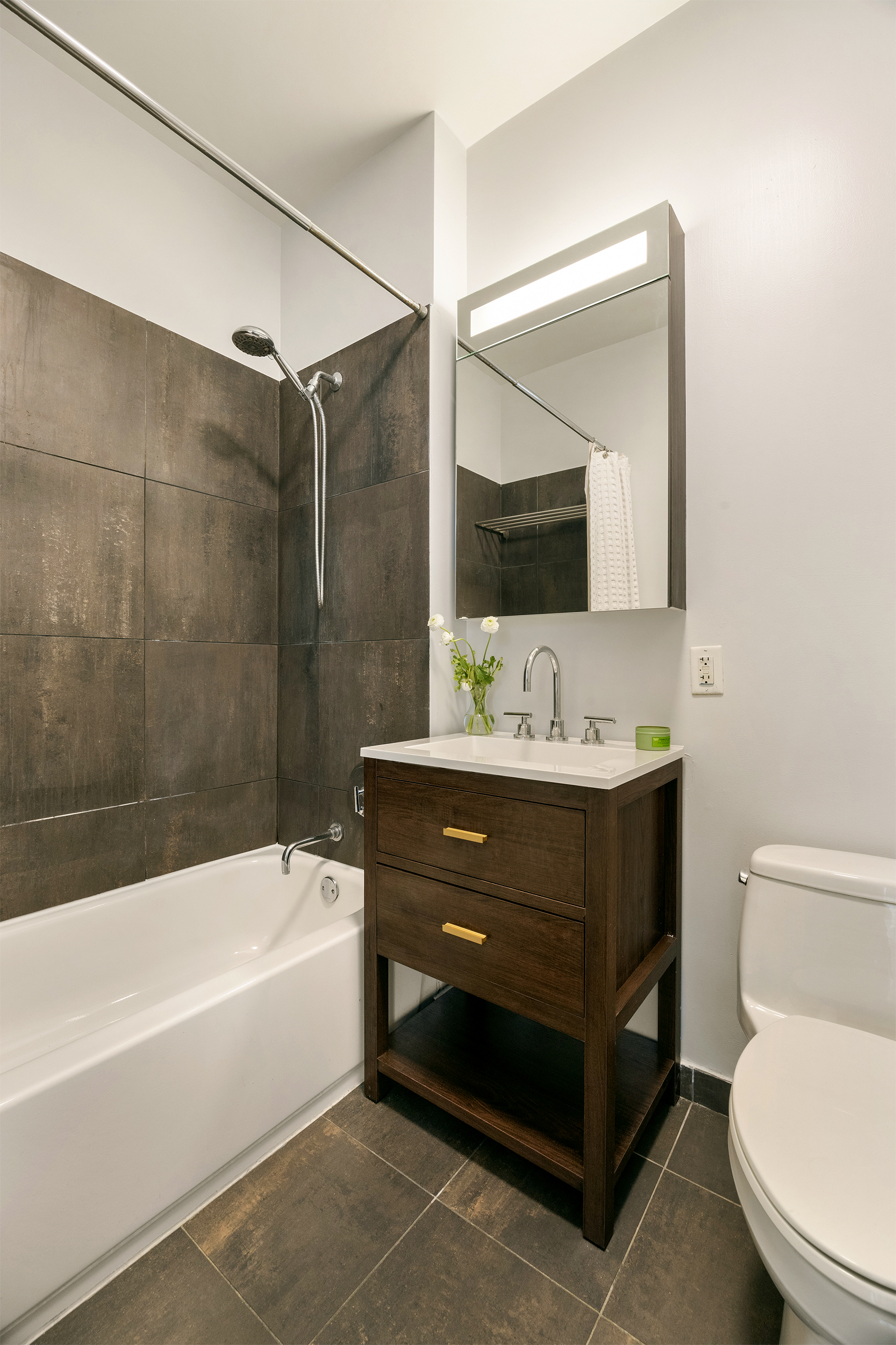 184 Kent Avenue, Unit B305 Brooklyn, NY 11249 - Photo 6 of 15 a bathroom with a bathtub shower sink vanity and toilet