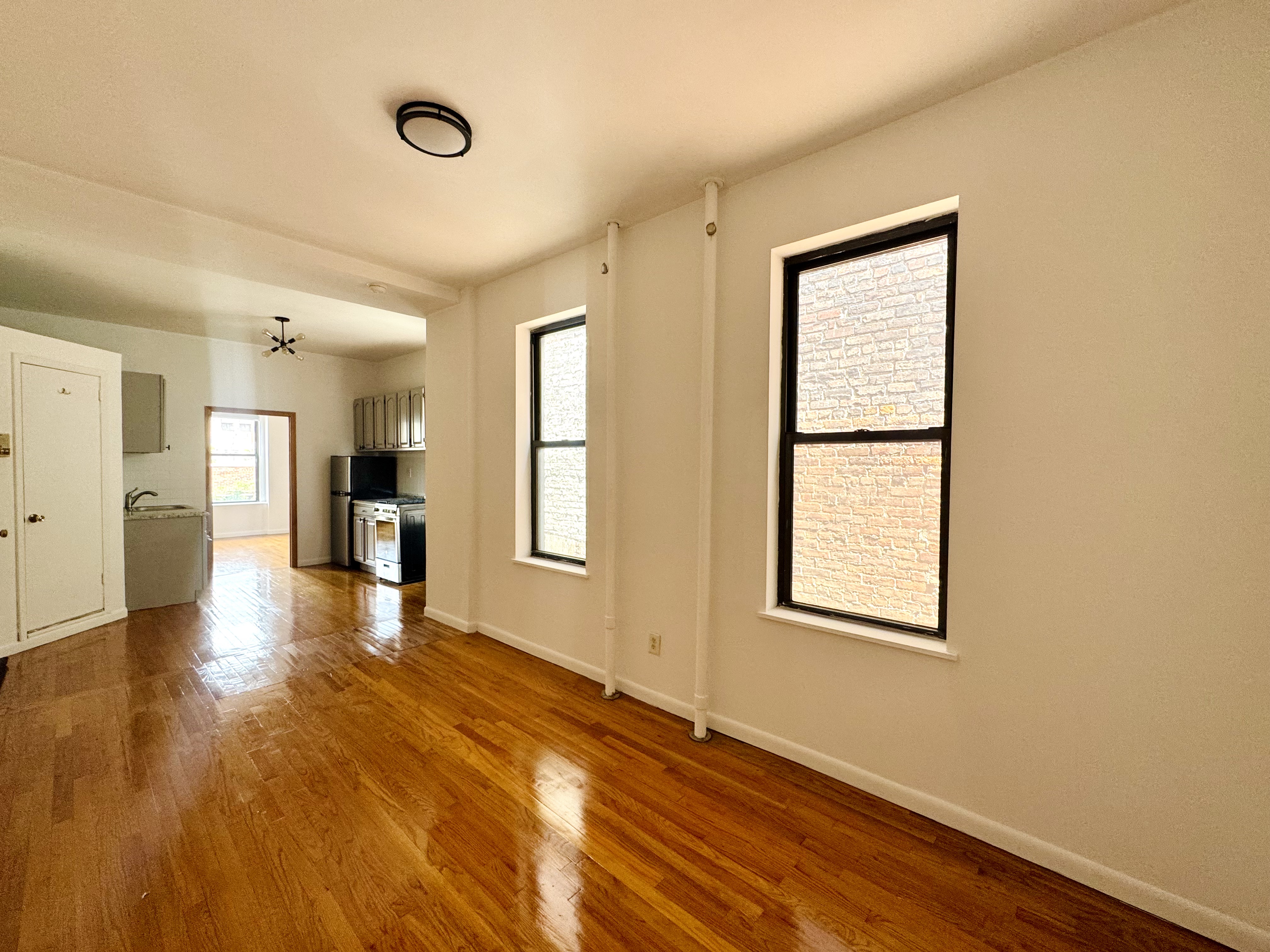 306 East 11th Street, Unit 5B Manhattan, NY 10003 - Photo 6 of 8 a view of an empty room with a window and wooden floor